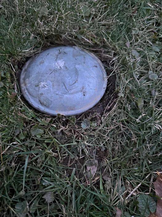 What is this ? I recently bought a new house and this is in my backyard. Looks like a cap of some sort, about 6 inches in diameter. Feels like metal and is embedded into the ground.